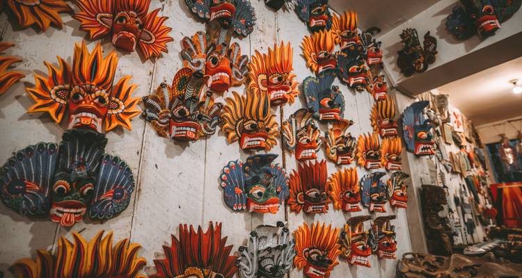 Wall of vibrant traditional Sri Lankan masks displayed in artisan shop