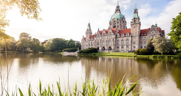 L'hôtel de ville néo-gothique de Hanovre se reflétant dans son bassin tranquille au milieu de jardins luxuriants.