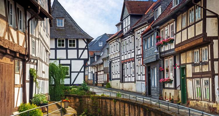 Narrow lane of timber-framed houses and stone canal in a traditional German town