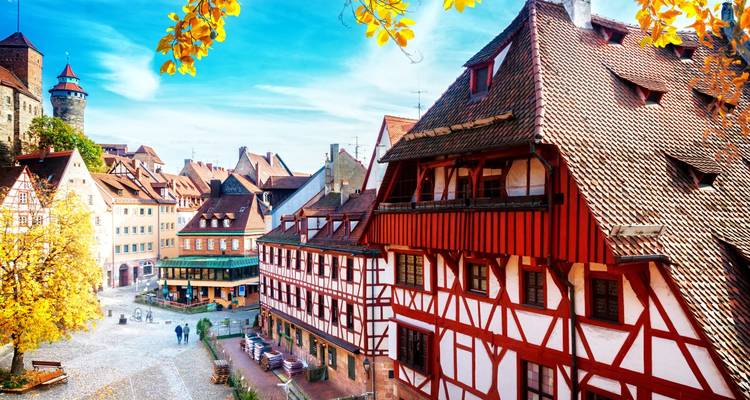 Autumn-tinged view over Nuremberg’s half-timber houses and castle tower under blue sky