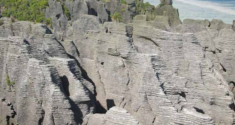 Les formations calcaires stratifiées connues sous le nom de roches-crêpes s'élèvent à côté des eaux côtières turquoise.