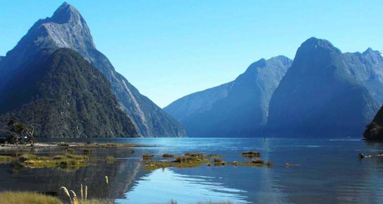 Le pic emblématique de Mitre s'élève au-dessus des eaux bleues et calmes du Milford Sound par une matinée cristalline.