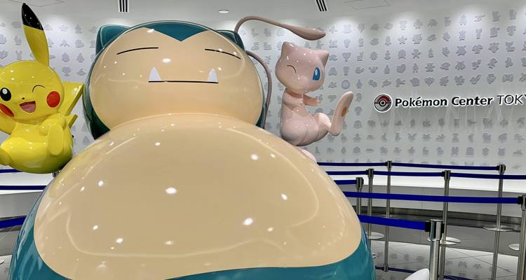 Large Snorlax and other Pokémon statues inside Pokémon Center Tokyo with branded backdrop.