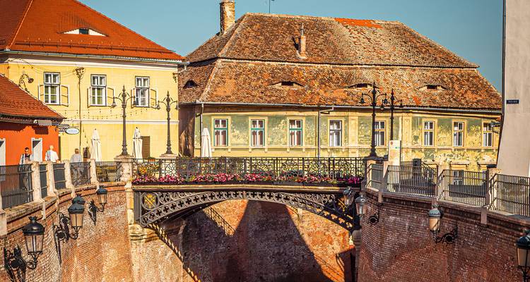 Le Pont historique des Mensonges avec sa rampe ornementale enjambe une rue étroite dans la vieille ville de Sibiu.