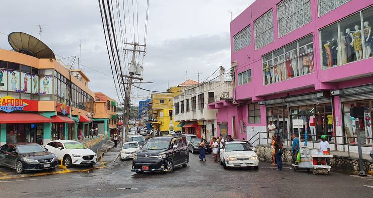 Rue du centre-ville animée bordée de bâtiments modernes colorés et de voitures par une journée pluvieuse