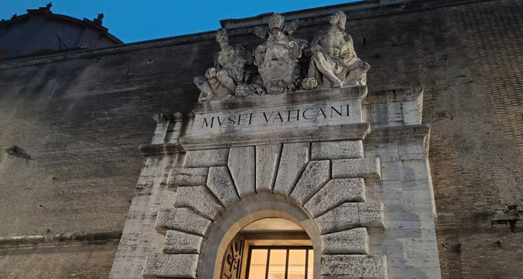 Stone entrance arch of the Vatican Museums with evening blue sky