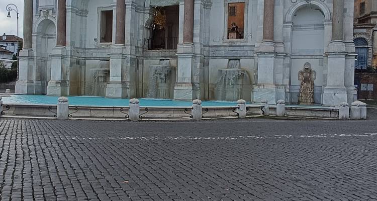 Lower pools and fountains of the Fontana dell'Acqua Paola with wet cobblestones in foreground