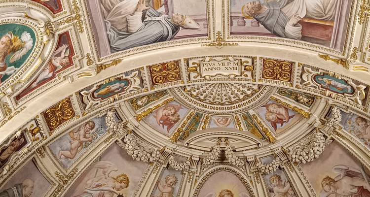 Highly detailed frescoed ceiling with cherubs and Latin inscriptions inside the Vatican Museums