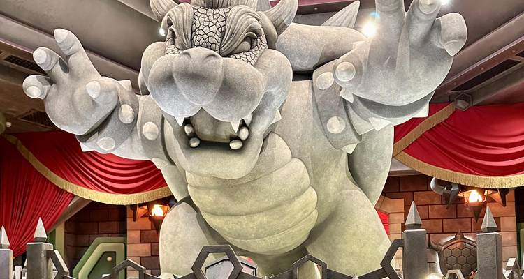 Close-up of imposing Bowser statue roaring inside Super Nintendo World attraction.
