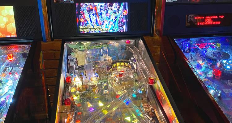 Close view of a colorful themed pinball machine with bright lights and graphics