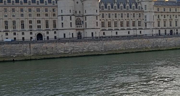 Historic Conciergerie building lining the River Seine viewed from across the water.