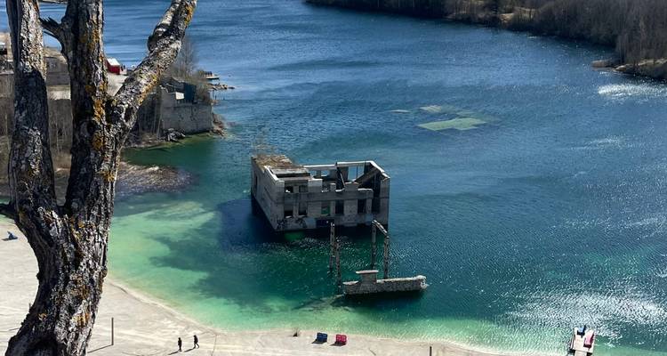 Vue de dessus du bâtiment immergé dans la carrière de Rummu entouré d'une eau bleu-vert éclatante