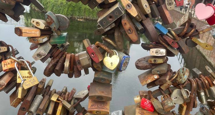 Gros plan de cadenas d'amour colorés regroupés sur la rampe d'un pont au-dessus de l'eau.