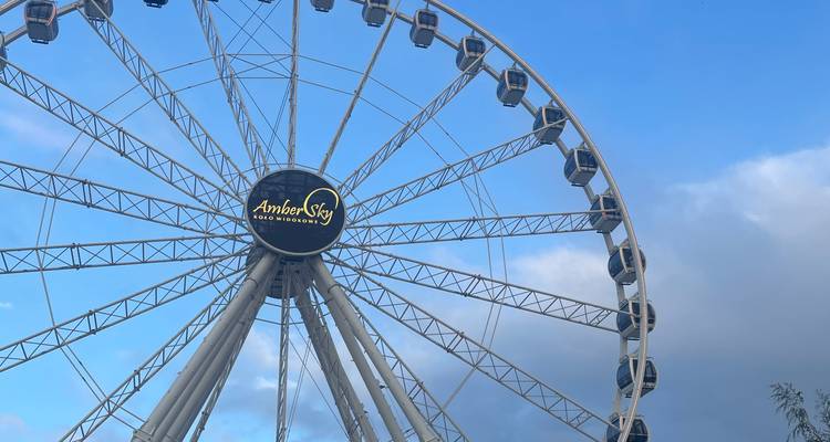 Grande roue AmberSky blanche sur un ciel bleu vif avec des nuages légers.