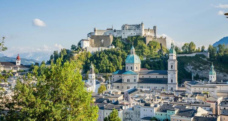 Vue par temps clair de la Forteresse de Hohensalzburg dominant la ligne d'horizon de Salzbourg au-dessus des dômes des églises et des toits.