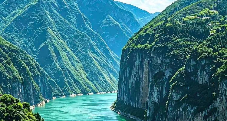 Des falaises verdoyantes plongent dans une rivière émeraude sinuant à travers une gorge spectaculaire par une journée claire.