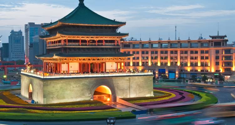 Les lumières du soir illuminent la Tour de la Cloche de Xi'an entourée par les traînées de circulation tourbillonnantes.