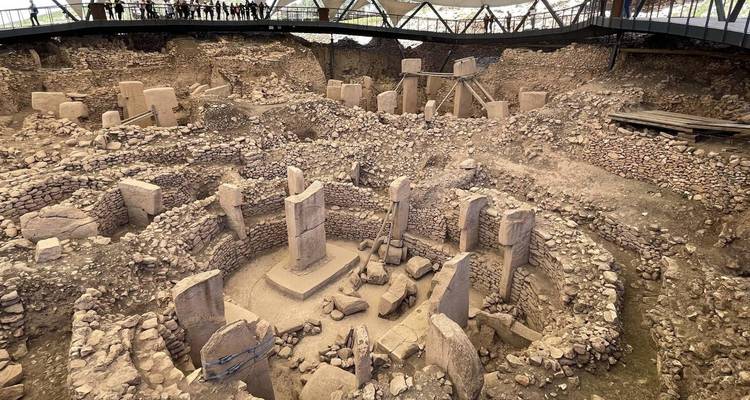 Overhead view into the circular stone enclosures of Göbekli Tepe archaeological site under a shelter.