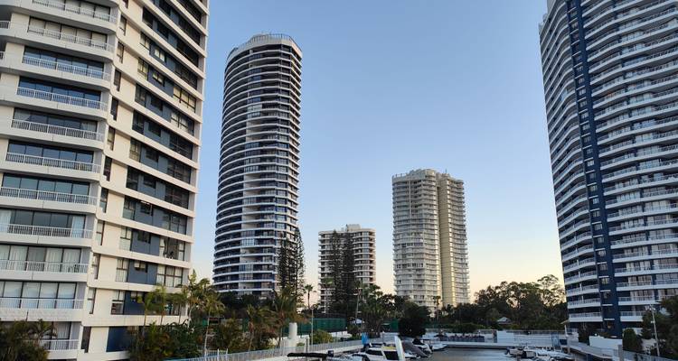 Modern high-rise apartment towers against a clear evening sky in Surfers Paradise marina district.