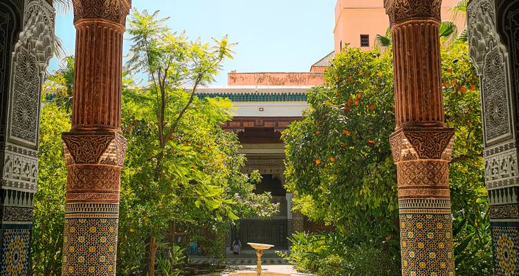 Lush courtyard garden framed by ornate columns in a Moroccan palace
