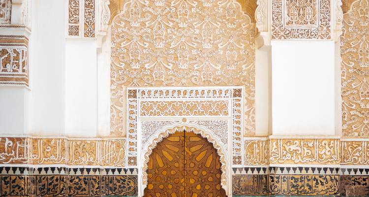 Detail of ornate Islamic door surrounded by carved stucco and tile patterns