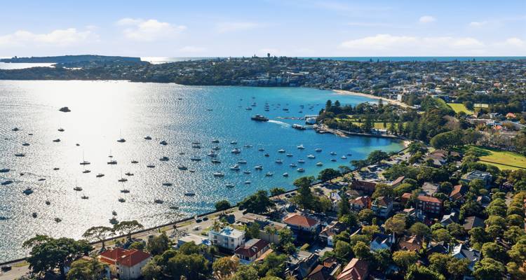 Port scintillant parsemé de voiliers à côté de banlieues résidentielles verdoyantes à Watsons Bay