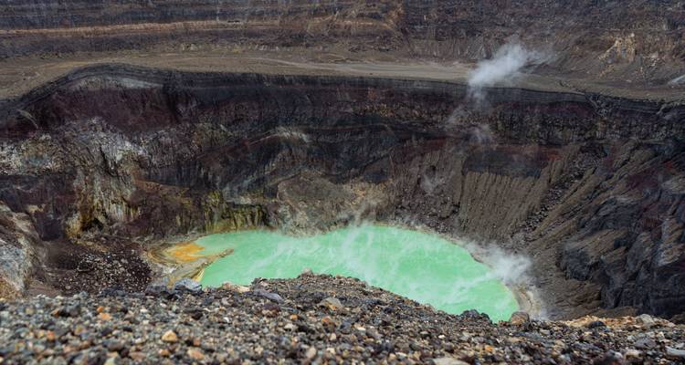Steaming turquoise crater lake inside the rugged caldera of Irazú Volcano.