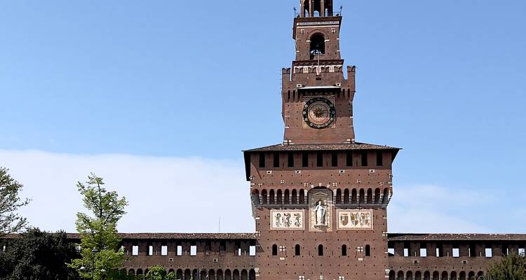 Tour centrale du Castello Sforzesco avec horloge et fresques sur un ciel bleu éclatant.
