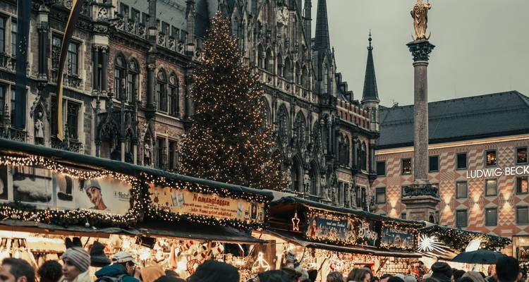 Les stands du marché de Noël bondé de Munich sous les façades gothiques et les lumières scintillantes.