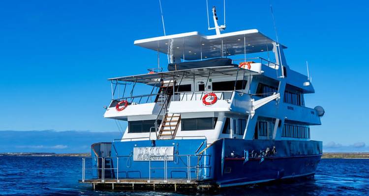 Vue arrière d'un yacht d'expédition avec plateforme de baignade et échelles dans des eaux bleu profond.