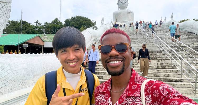 Deux amis sourient pour un selfie dans l'escalier menant à la statue du Grand Bouddha de Phuket.