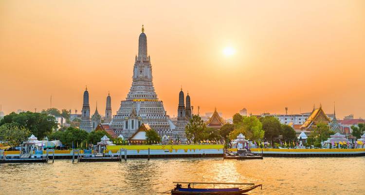 Les temples de Wat Arun et ses environs de Bangkok s'illuminent au coucher du soleil en face du fleuve Chao Phraya.