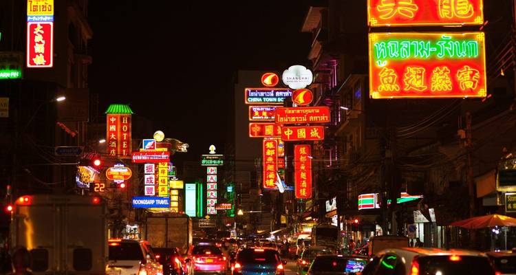 Le quartier chinois de Bangkok brille avec des enseignes au néon colorées et un trafic intense lors d'une nuit animée.