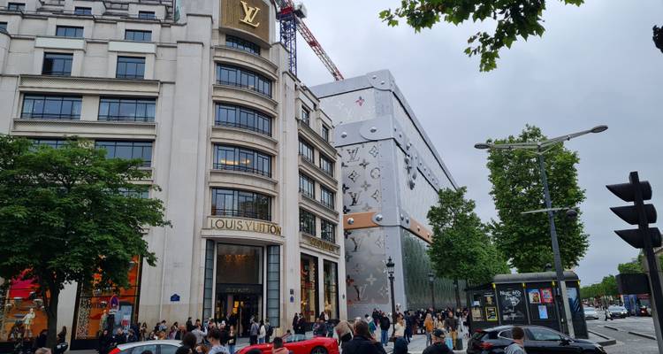 District commercial animé de l'Avenue des Champs-Élysées avec le magasin phare Louis Vuitton et la foule.