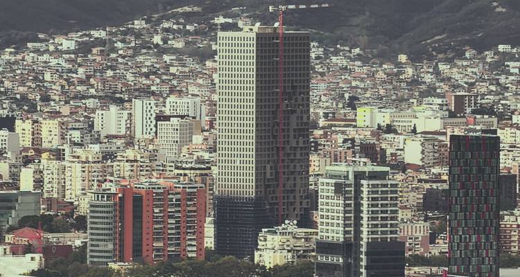 Vista de teleobjetivo del horizonte de Tirana con torres modernas de gran altura densamente empaquetadas contra las colinas circundantes.