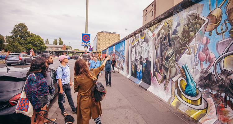 Le guide explique les fresques colorées de l'East Side Gallery du Mur de Berlin aux visiteurs