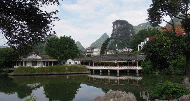"Bâtiments traditionnels se reflétant dans une étendue d'eau tranquille."