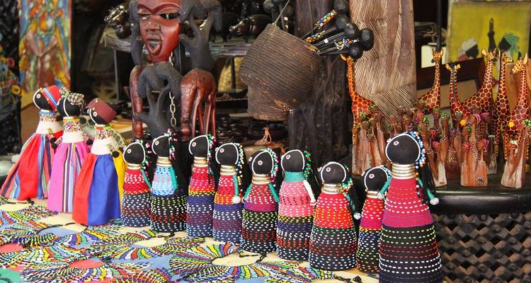 Poupées colorées en perles et objets artisanaux exposés.