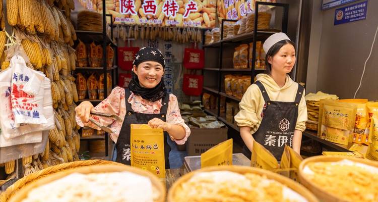 Deux femmes dans un étal de marché exposant des produits locaux à Xi'an, Chine.
