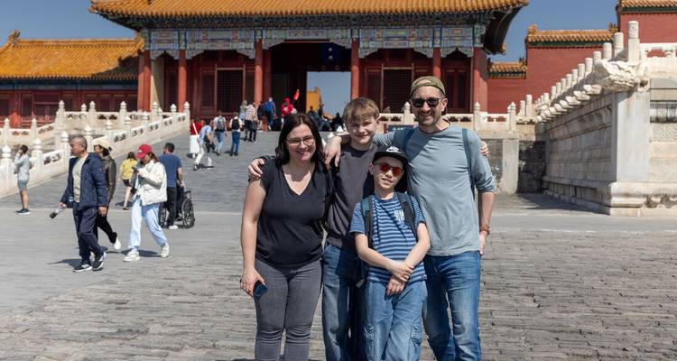Una familia posando frente a una puerta histórica en Pekín.