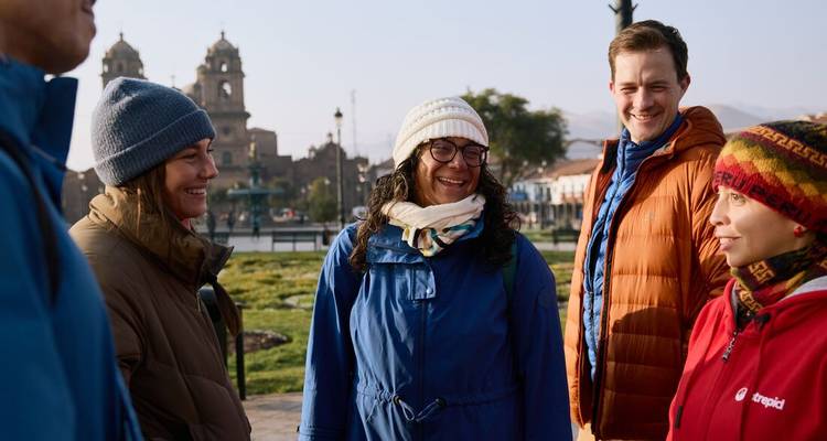 Group of people in warm clothing chatting outdoors.