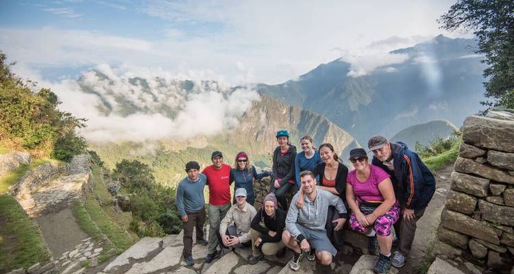 Group of hikers at a scenic viewpoint with mountainous background.