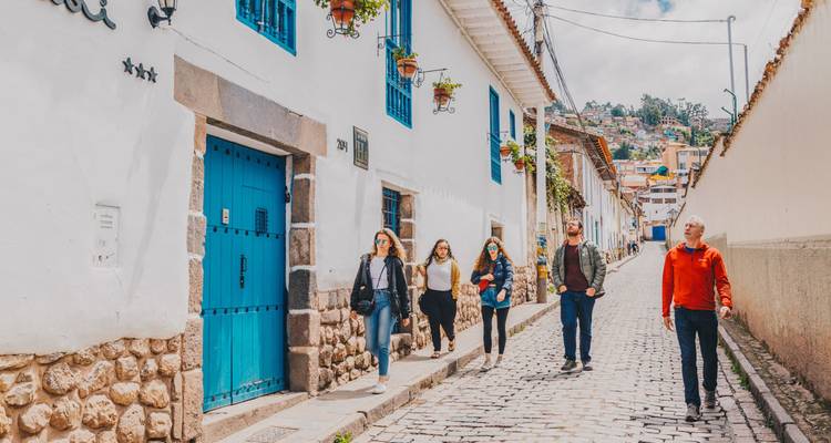 People walking on a cobblestone street with historic buildings.