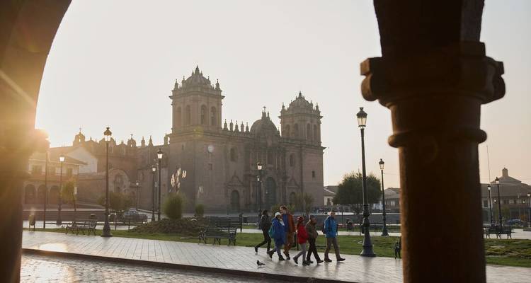 Un groupe de personnes marchant devant une église historique sur une place.