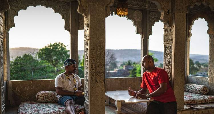 Two people having a conversation in a traditional courtyard.