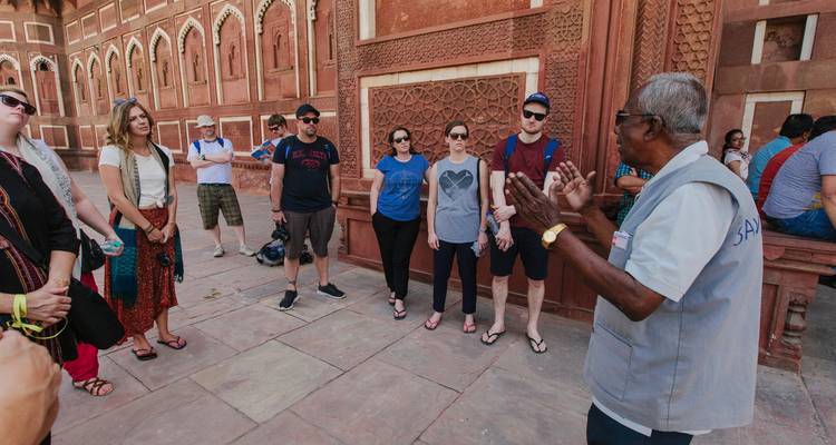 Groupe de touristes guidés devant un bâtiment historique.