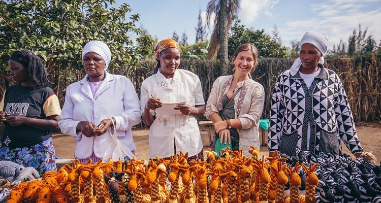Femmes en tenue traditionnelle debout à un étal de marché.