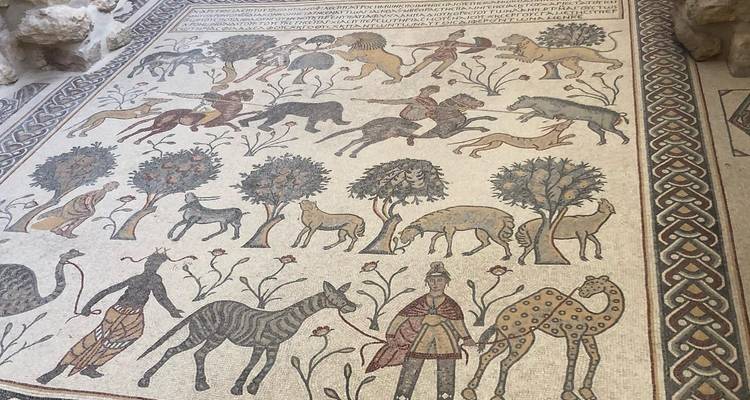 Suelo de mosaico ornamentado que representa animales y árboles.