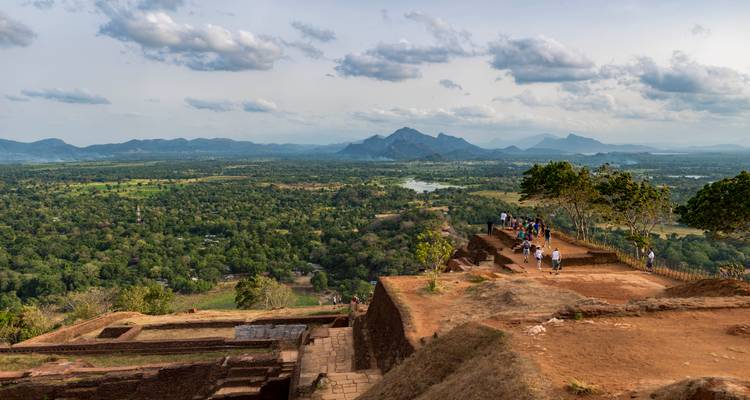 Amplia vista desde la cumbre de Sigiriya sobre el frondoso bosque y las montañas azul grisáceas a lo lejos.