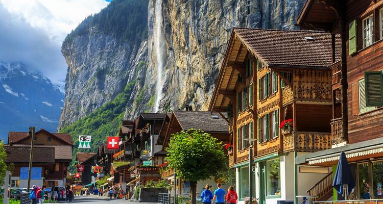 Village suisse traditionnel avec cascade et montagnes.